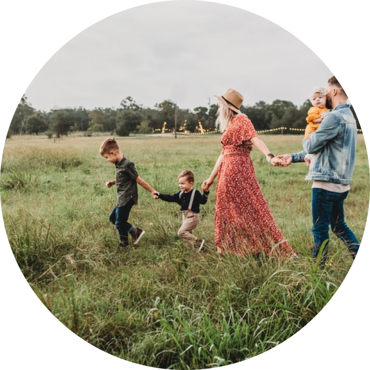 young family walking through meadow